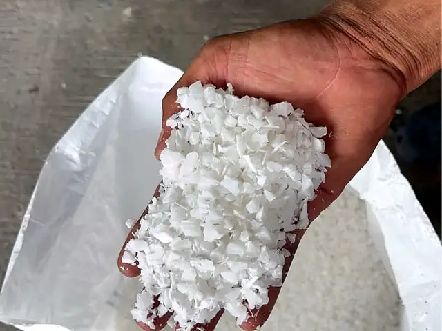 เศษบดสีขาวในมือ เหนือถุงเศษบด
