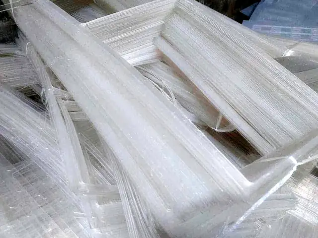 Stacked clear sheet edge trim left over from forming