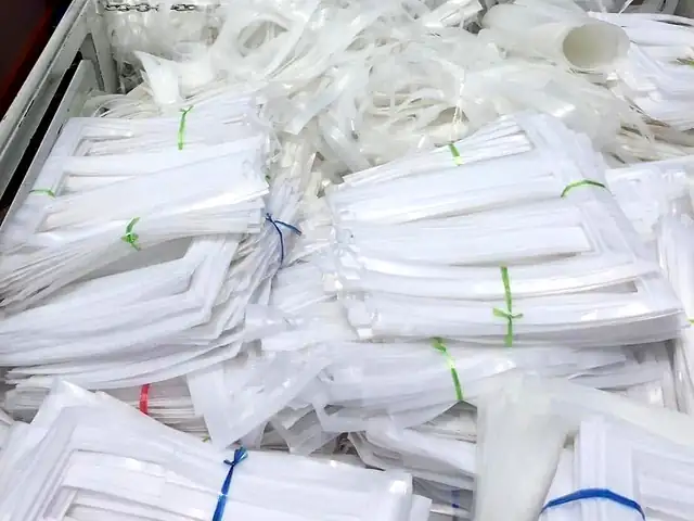 โครงแผ่นพลาสติกสีขาวที่เหลือจากการตัด มัดเป็นมัด